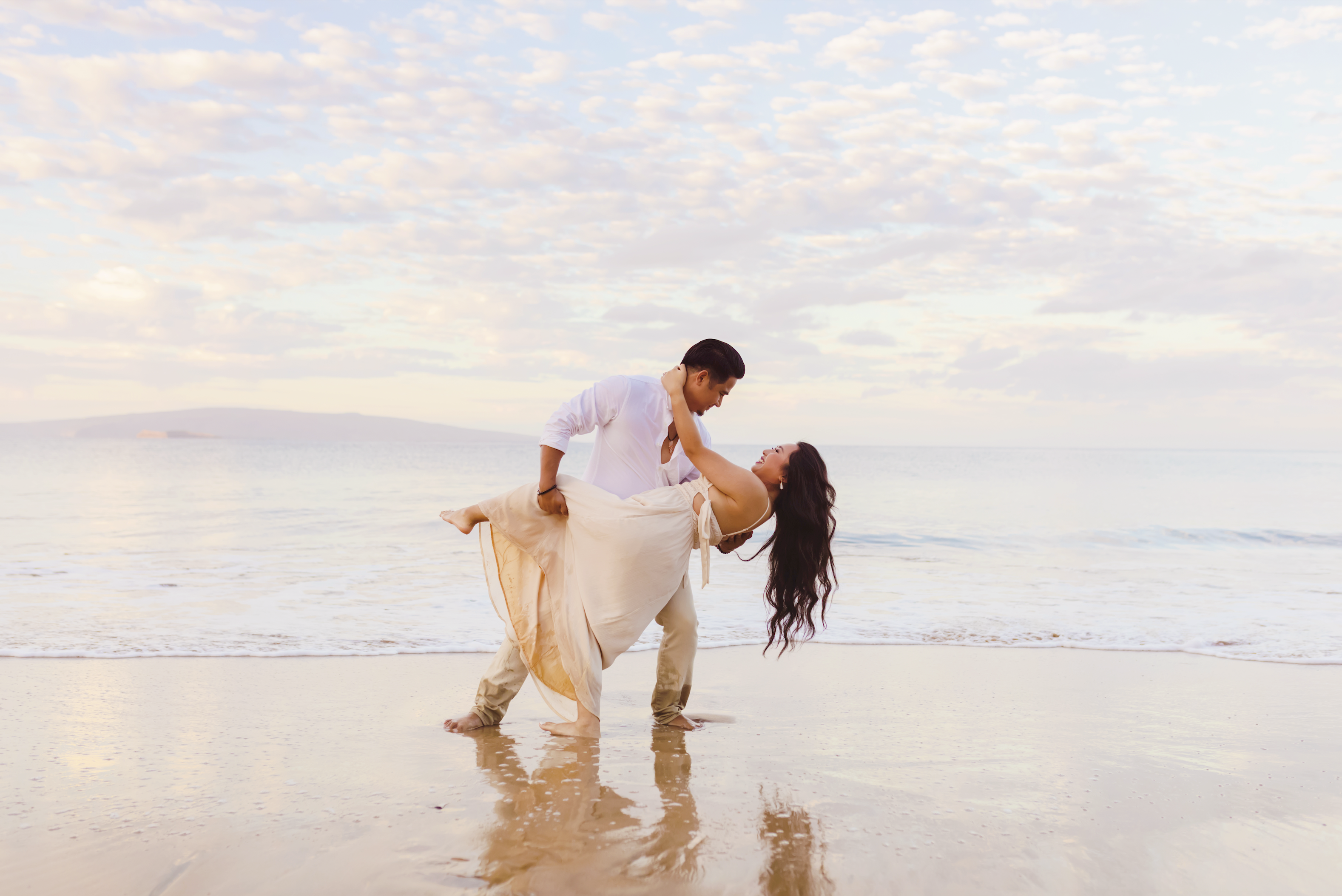 sweet couple dip on the beach at sunrise in wailea, maui, photographed by love and water photography on maui